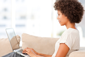 Young Woman Typing on a Laptop at Home